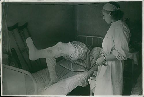 Ayakta duran ve hasta pansumanlarına bakan bir hemşirenin vintage fotoğrafı.Russian_ soldierhospital 1943fiziksel